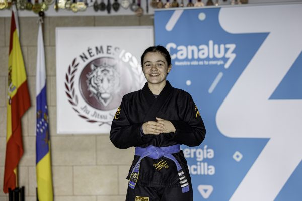 La medallista mundial, Iris García, joven promesa del Grappling español, posa en su gimnasio junto a la marca Canaluz y el escudo del Team Némesis. FIRMA FOTOS: MARCOS DE RADA.